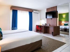 Ibis Styles Cayenne Centre Amazonia客房内的一张或多张床位