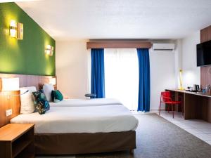 Ibis Styles Cayenne Centre Amazonia客房内的一张或多张床位