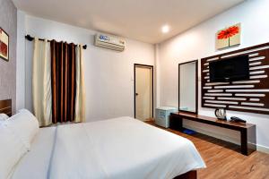 a bedroom with a white bed and a television at S79 Residences SEN in Ho Chi Minh City