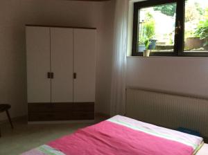 a bedroom with a bed and a cabinet and a window at Fewo Blütenreich in Traben-Trarbach