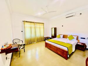 Un dormitorio con una cama y un escritorio en una habitación. en Deanna Inn, en Anuradhapura