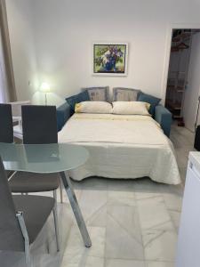 a bed in a room with a table and a bed at Apartamento Calle Nueva in Cádiz