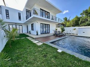 a villa with a swimming pool and a house at Lotus D`Or Villa in Trou aux Biches