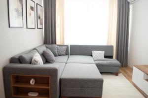 a living room with a gray couch and a window at Luxe Suite AI28 in Esenyurt