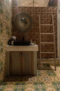 a room with a table and a fan on a wall at Tropical Traditional Indonesian Wooden Cottage - Beji Mas, Ubud in Ubud