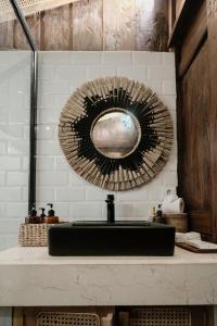 a bathroom sink with a mirror on the wall at Tropical Traditional Indonesian Wooden Cottage - Beji Mas, Ubud in Ubud