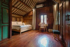 a bedroom with a bed and a table in it at Tropical Traditional Indonesian Wooden Cottage - Beji Mas, Ubud in Ubud +23 photos