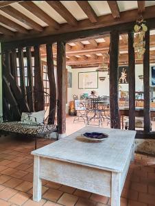a living room with a table and chairs on a patio at La maison bleue in Reux