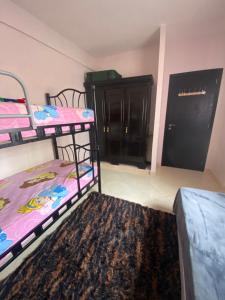 una habitación con dos literas y una alfombra en Appartement confortable et ensoleillée, en Aïn Harrouda