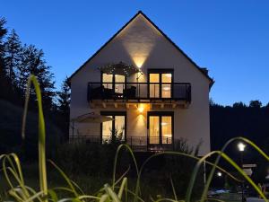 a large white house with a balcony at night at Blue Sky Flat, Apartment, 73qm, 4-6 Personen, Neubau Süd-Balkon mit Lounge-Möbeln, Schwarzwald-PLUS inkl 80 Gratis-Attraktionen täglich in Baiersbronn