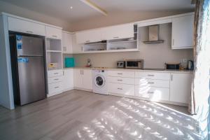 a kitchen with white cabinets and a washer and dryer at Graf Victor Apart Hotel in Alanya