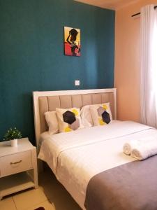 EmbuEmbu Air-bnb 1&2 Bedroom homestay的一间有两张床和一面绿墙的卧室
