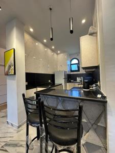 a kitchen with two chairs sitting at a bar at فيلا بمسبح خاص وتشطيب فاخر قرب البحيرة in El Alamein +51 photos