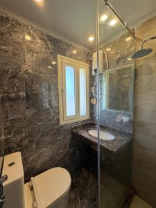 a bathroom with a toilet and a sink and a shower at فيلا بمسبح خاص وتشطيب فاخر قرب البحيرة in El Alamein