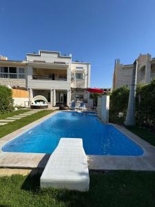 a swimming pool in front of a house at فيلا بمسبح خاص وتشطيب فاخر قرب البحيرة in El Alamein