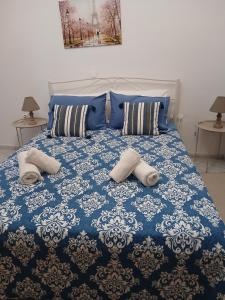 a blue and white bed with two pillows on it at Josephine's House in Neochórion