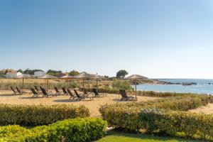 a group of chairs and umbrellas on a beach at Sandoa Residence - Lualaba & Tenke in Minia