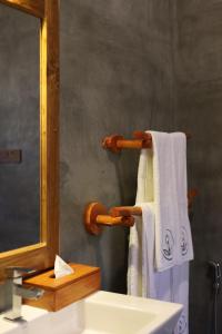 a bathroom with a sink and a mirror and towels at The Coconut Experience Eco Lodge Wilpattu in Nagamadu +105 photos