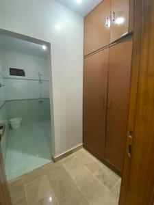 a bathroom with a shower and a toilet and a glass door at Johar Guesthouse-Suite 3Bed and Lounge in Karachi in Karachi +47 photos