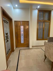 a hallway with a wooden door and windows at Johar Guesthouse-Suite 3Bed and Lounge in Karachi in Karachi