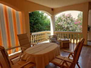 a porch with a bed and chairs and a large window at Goga apartment in Petrcane