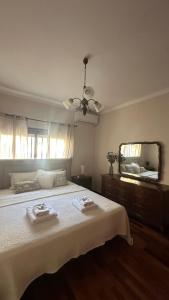 a bedroom with a large bed and a mirror at Casa Sol e Mar by Férias em Figueira in Figueira da Foz