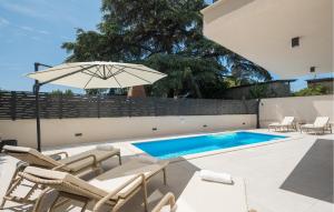 un patio avec des chaises et un parasol à côté d'une piscine dans l'établissement Nice Apartment In Tar, à Tar