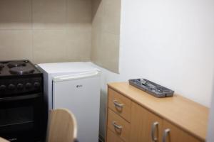 a small kitchen with a stove and a white refrigerator at Dolce Vita in Kraljevo
