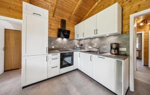 a kitchen with white cabinets and a wooden ceiling at Ferienhaus Haren in Haren