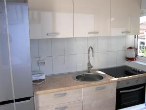 a kitchen with a sink and white cabinets at Apartment GRANDE in Preko +31 photos