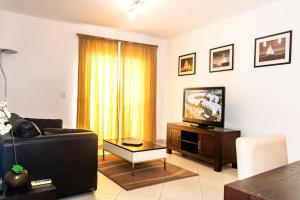 a living room with a couch and a television at HostySpot - Melia Dunas in Santa Maria