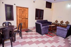 sala de estar con mesa, silla y sofá en Coorg mansion, en Madikeri 30 fotos más