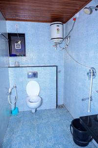 マディケーリにあるCoorg mansionのバスルーム(トイレ付)、壁にバケツが備わります。