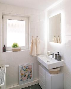 a white bathroom with a sink and a window at Deluxe Koblenz Flat, Parken, Netflix, Ruhig in Bendorf