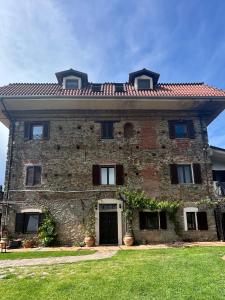 a large brick building with a roof at Cascina Ciosse apartament in Grognardo