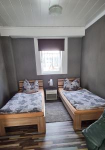 a bedroom with two beds and a window at Kleine Wohnung an der Werra in Witzenhausen
