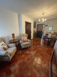 Una sala de estar con dos sillas y un sofá. en Apartamentos Torre Villar, en Villar de Vildas