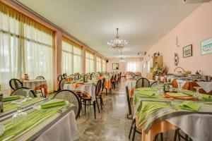 Hotel Diamante في ريميني: غرفة طعام مع طاولات وكراسي بمناديل خضراء