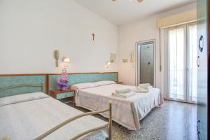 una camera ospedaliera con due letti e una finestra di Hotel Diamante a Rimini