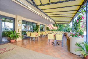 a patio with chairs and tables and plants at Hotel Diamante COLAZIONE XL PARCHEGGIO GRATIS A 5 CHILOMETRI DA RIMINI FIERA in Rimini
