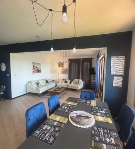 a living room with a table and blue chairs at Marina Cape Sky View Lux Apartment in Aheloy in Aheloy