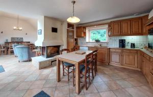 a kitchen with a table and a fireplace at Grande Longère Bretonne in Silfiac