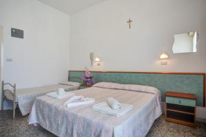 Hotel Diamante في ريميني: سريرين في غرفة عليها مناشف