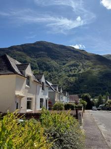 a row of houses on a street with a mountain at Mountain View House Kinlochleven in Kinlochleven +18 photos