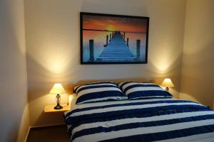 a bedroom with a bed with a painting on the wall at Koserow, Förster-Schrödter-Str 16 WE 2 in Ostseebad Koserow