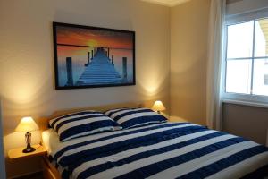 a bedroom with a blue and white striped bed with two pillows at Koserow, Förster-Schrödter-Str 16 WE 2 in Ostseebad Koserow +3 photos