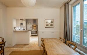 a dining room with a table and a kitchen at Charmante Maison De Ville in Chantilly