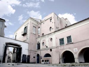 an old white building with an archway in front of it at Casa Vacanze VENUS in Venosa