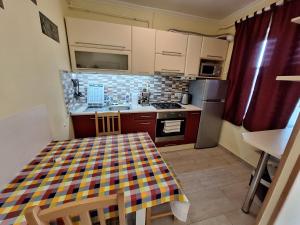 a kitchen with a table with a checkered table cloth on it at Anikó Apartman in Siófok