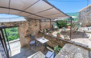 a patio with a table and chairs under an umbrella at 3 Bedroom Stunning Home In Saignon in Saignon +16 photos